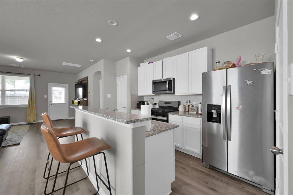 Modern kitchen with stainless steel appliances and breakfast bar.