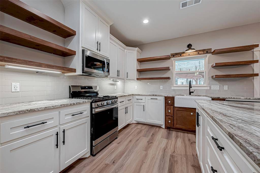 The kitchen boasts custom soft-close wooden cabinets.