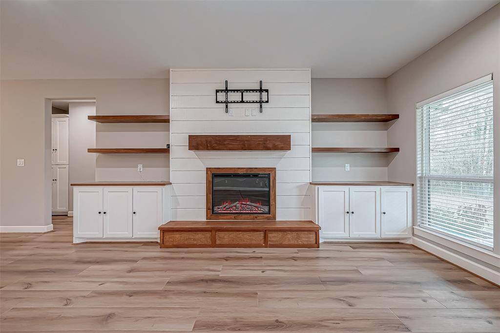 The living room features floating shelves, and a fireplace.