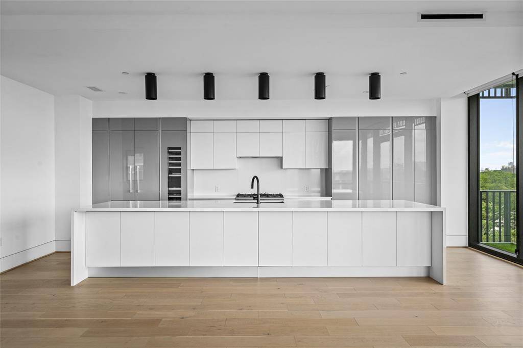 The generous kitchen island enhances the space with room for cooking, serving, and storage.