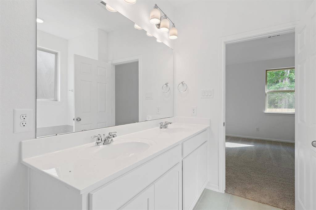 The en-suite bathroom offers a spa-like atmosphere with its elegant design, high end finishes, and tasteful lighting, creating a retreat within your own home.