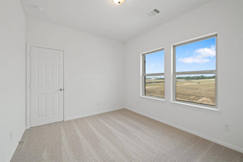 Your secondary bedroom features plush carpet, fresh paint, closet, and a large window that lets in plenty of natural lighting.