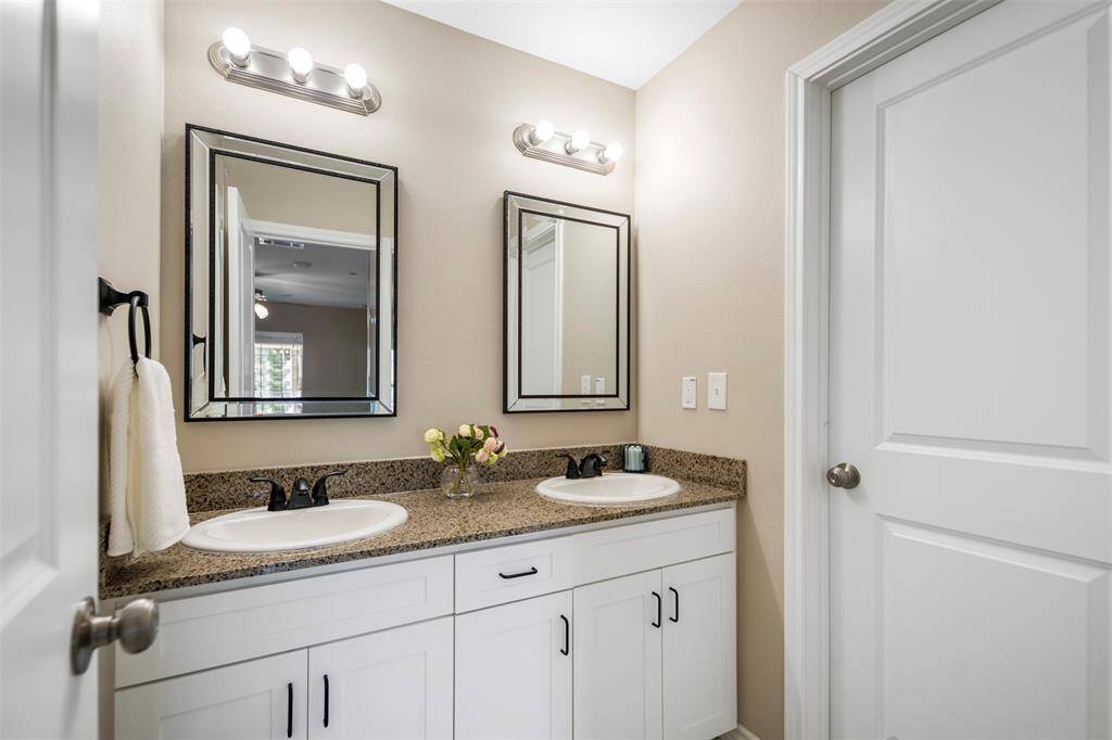 Well-appointed ensuite bath featuring a separate vanity area, with a door that provides privacy for the toilet and shower. This layout offers convenient access to the toilet from the hall, making it guest-friendly while maintaining privacy in the rest of the bathroom.