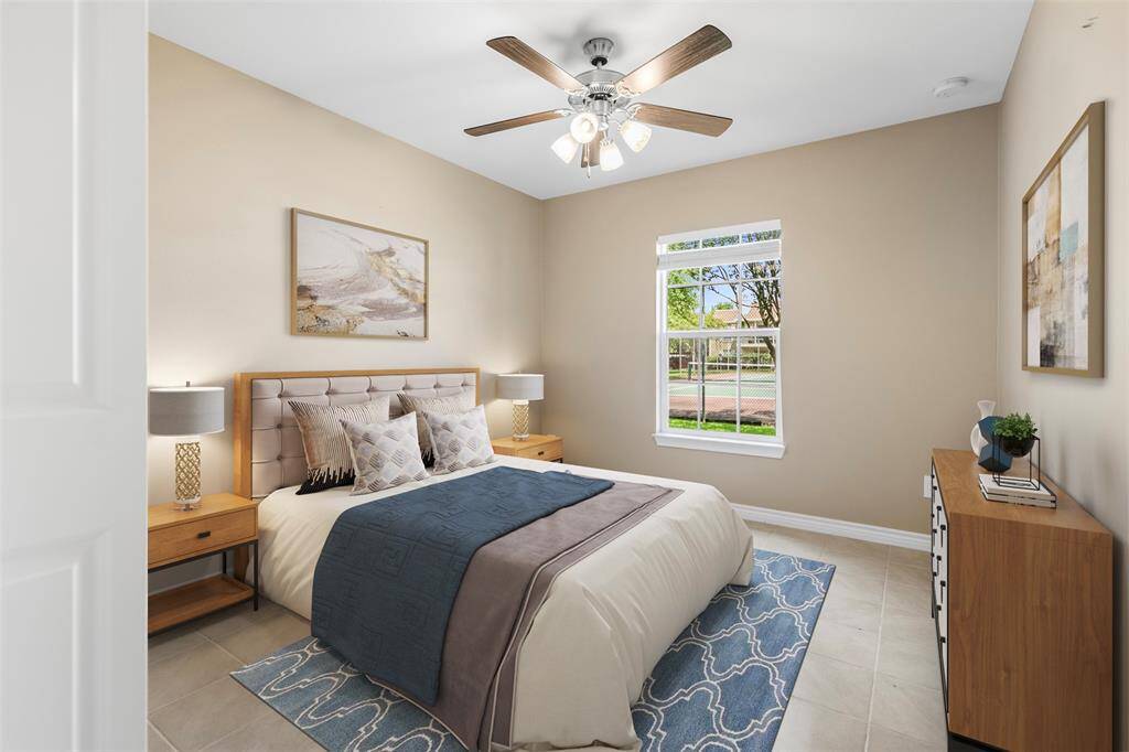 Cozy secondary bedroom featuring a ceiling fan, calming cool tones, and a spacious closet—offering a comfortable and versatile space for relaxation or a home office.(This photo is virtually staged)