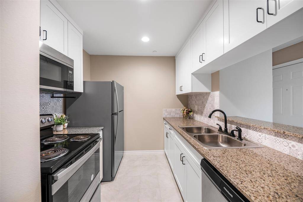 Modern kitchen featuring crisp white cabinetry, sleek black hardware, and stainless steel appliances—combining style and functionality in a fresh, contemporary space.