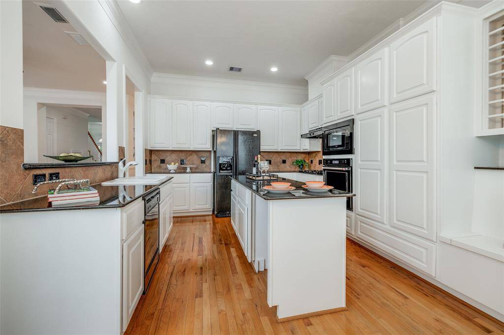 Spacious Kitchen with recently painted white cabinets, single oven, microwave, white sink