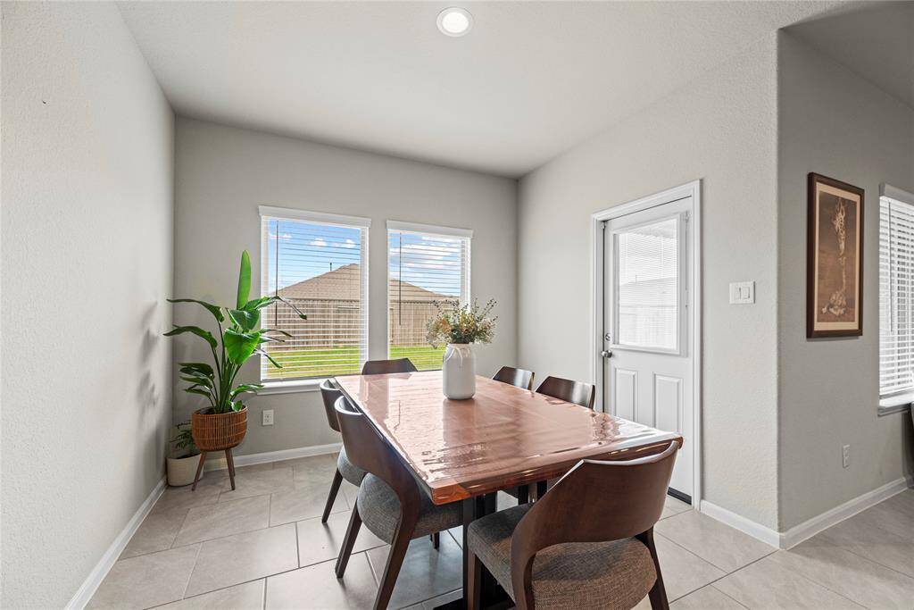 The dining area is ideal for a full-sized table and features easy care tile floors, large bright windows, and easy access to the backyard.