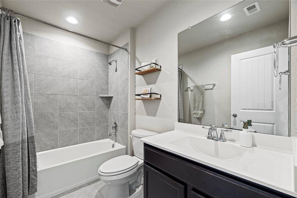 The upstairs secondary full bath with large vanity.