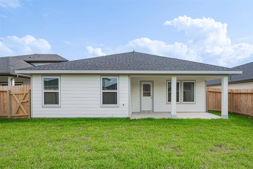 The covered patio provides a shaded outdoor living area ideal for relaxing or dining al fresco, all while overlooking the expansive yard and rear elevation of the home.
