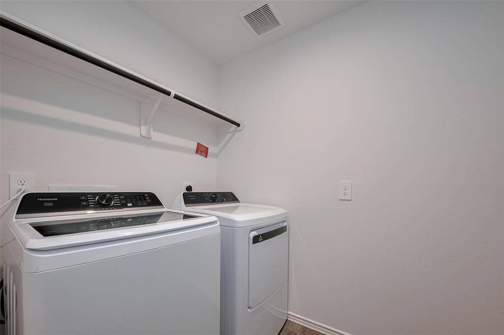 Thoughtfully designed with a built-in overhead rack and hanging rod, the laundry room offers both function and elbow room—making daily chores a little more efficient.