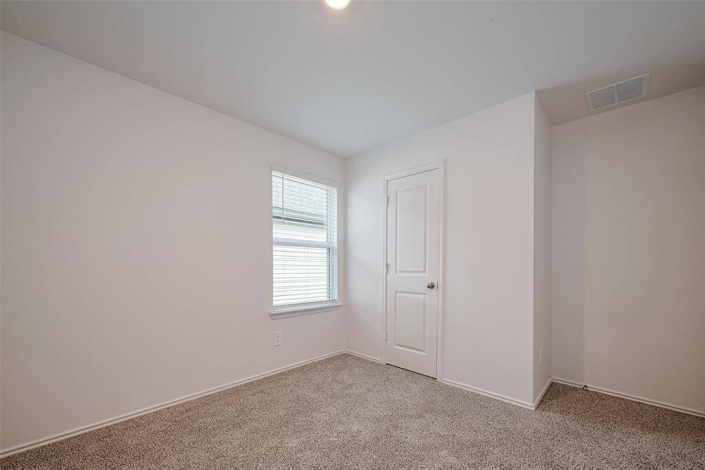 A peaceful retreat, this carpeted bedroom features a window that fills the room with daylight, set against soft, neutral tones for a calming atmosphere.