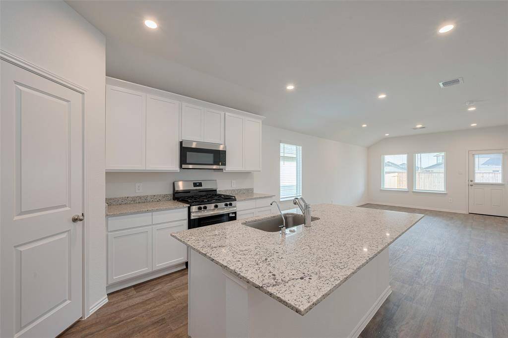 The kitchen centers around a generous island, ideal for casual seating or prep space.
