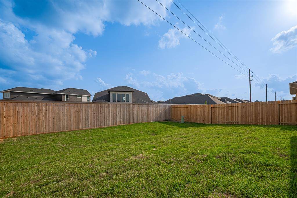 A spacious, fully fenced backyard offers an expanse of lush grass—ideal for outdoor enjoyment or future customization.