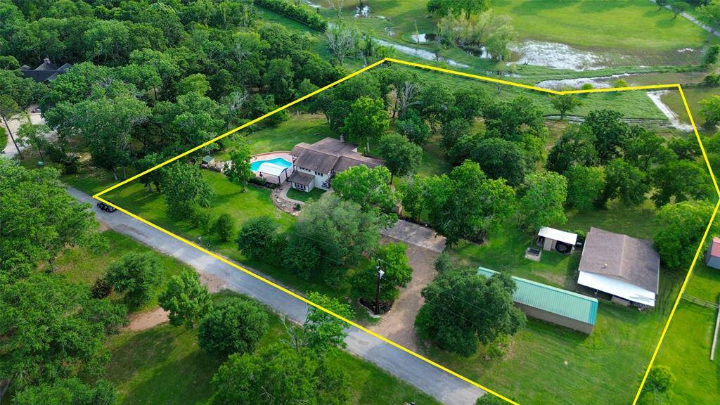 This 3.4-acre ranchette, scattered with mature trees, includes a primary residence, multi-stall horse barn and an additional outbuilding. *Property lines are approximated*