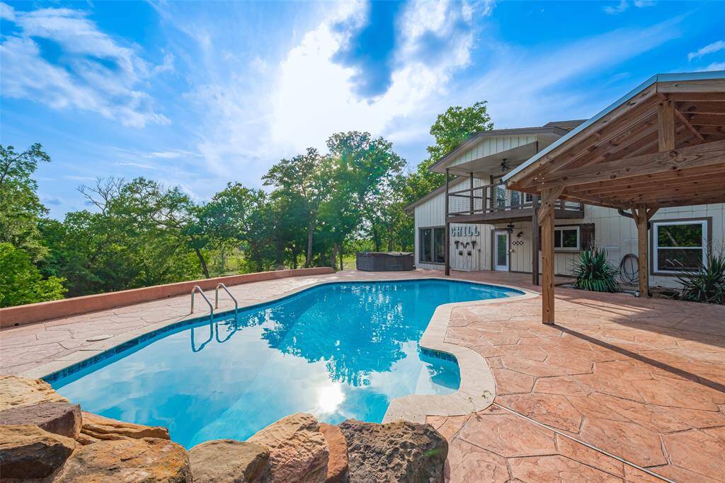 This sparkling pool is an open invitation. Whether you're swimming, lounging, or entertaining, this outdoor space is designed for both comfort and beauty. The expansive patio surrounds the pool, perfect for sunbathing, dining, or enjoying the tranquility of nature. A balcony overlooks this serene retreat, offering a peaceful spot to unwind & take in the breathtaking views. The covered patios provide additional shaded areas for outdoor living, allowing you to entertain in style or simply enjoy the outdoors!