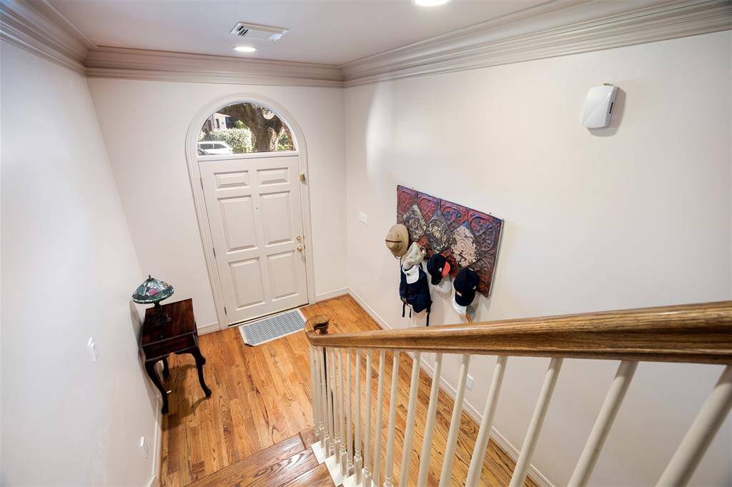 The entry hall offers red oak hardwood flooring, neutral paint colors and recessed lighting.