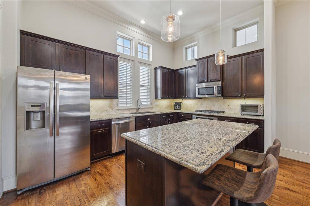 Island kitchen with granite countertops, under cabinet lighting, gas range, walk-in pantry and plenty of storage.