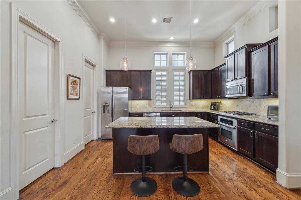View of the kitchen with the half bath to the left and the pantry by the refrigerator.