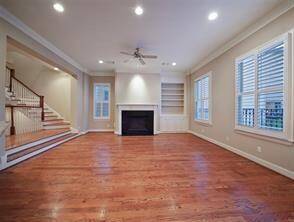 This view showcases the gas log fireplace, featuring granite tile surround and a custom-built bookcase to the right.