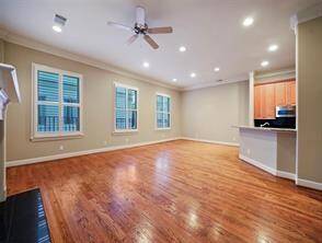 This view highlights the open living area, featuring a long breakfast bar that seamlessly separates the living room from the kitchen. A formal dining table could be positioned toward the back of the space to enhance the space's versatility.
