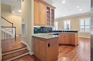 This view highlights the rear entry to the kitchen, accessible from the spacious second floor landing, seamlessly connecting the kitchen to the upper level of the home. Also, the powder room is located to the left on the landing.