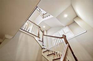 This striking staircase showcases built-in display ledges at each mid-floor landing with large windows that flood the space with natural light.