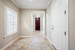 The view highlights the spacious foyer looking back toward the front door. There are two generous storage closets on the left, inside you'll find ample storage with built-in shelving and hanging rods, perfect for organization.