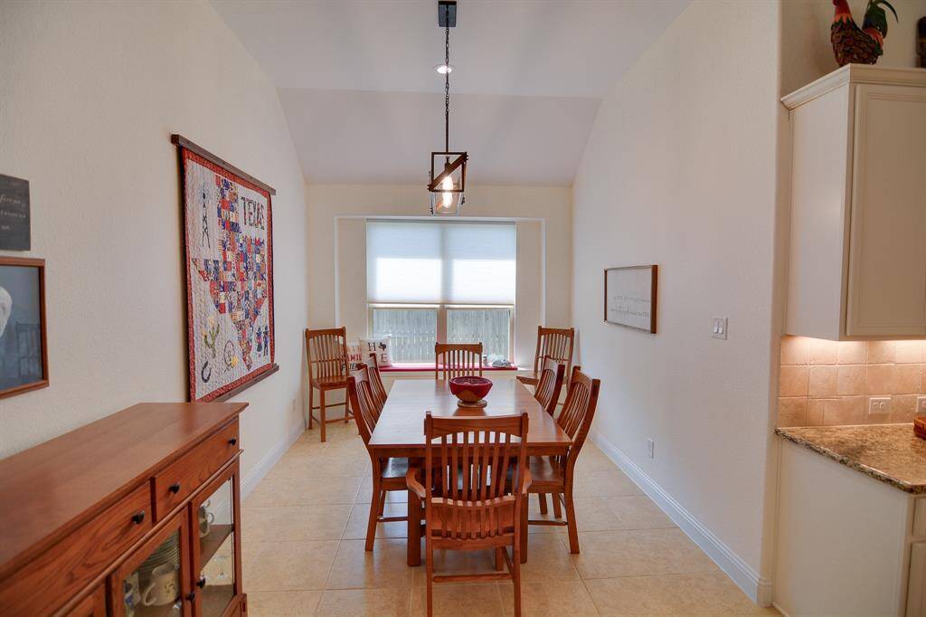 This stunning dining area features soaring high ceilings, recessed lighting, and tile flooring, creating an open and airy atmosphere. The expansive layout offers ample room for personalization, while the sleek modern chandelier adds a touch of elegance. Perfect for both relaxing and entertaining, this room seamlessly connects to the kitchen, enhancing the flow of the open floor plan.