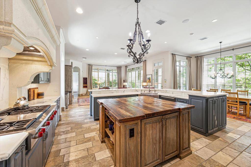 This gourmet kitchen features European white marble counters, 100+ year old oak wood island. Built in top of line Wolf and Sub-Zero appliances. Custom designed vent hood and commercial grade cooktop. Butlers pantry and walk-in wet bar around corner.
