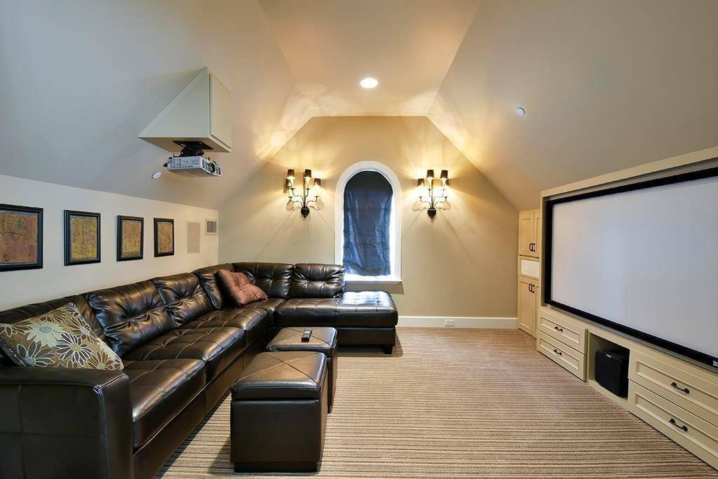 Sophisticated media room off the second floor game room, featuring a large screen, and elegant sconce lighting - perfect for movie nights.