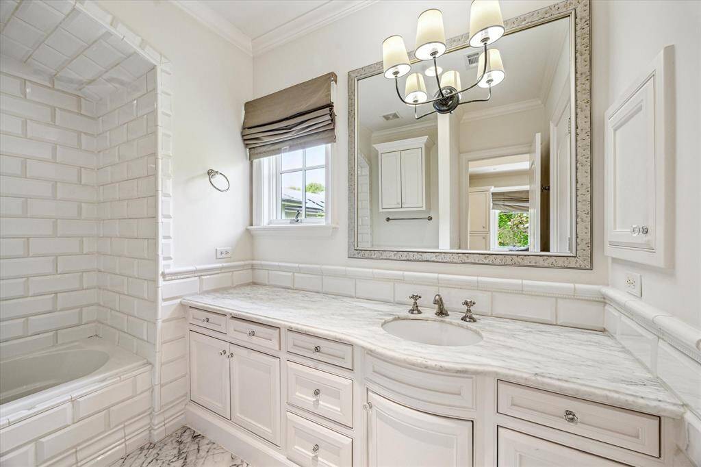 Elegant en-suite bathroom, adjoins Bedroom #2 featuring white marble flooring and a spacious white marble vanity.