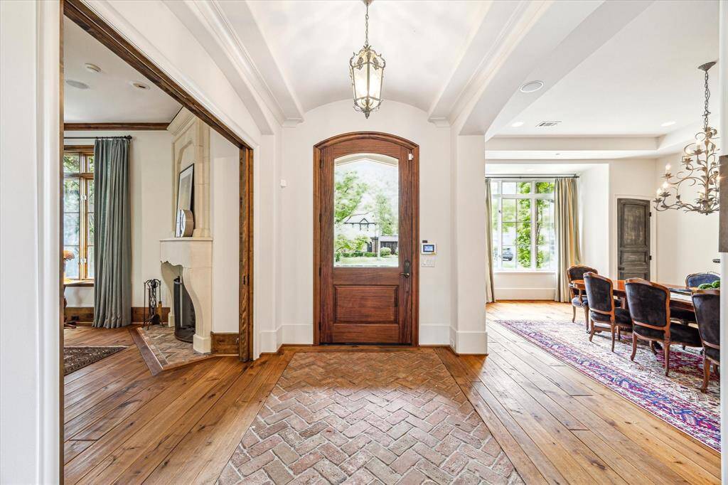 Grand entryway with a striking brick herringbone pattern inlay and seamless flow - study on the left, formal dining on the right, perfect for sophisticated living.