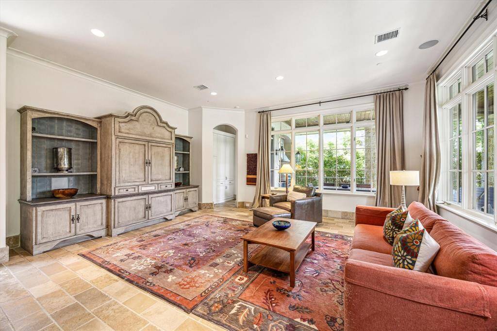 Spacious family room open to the kitchen and breakfast area, featuring a beautiful custom built-in, ceiling speakers (also in every room in the house & patio) with a control pad, a convenient 2nd powder bath, large windows with views of the patio, backyard, and pool bright and inviting.