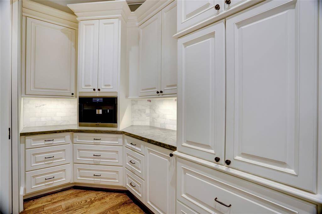 Large walk-in pantry with floor to ceiling shelving and refrigerator