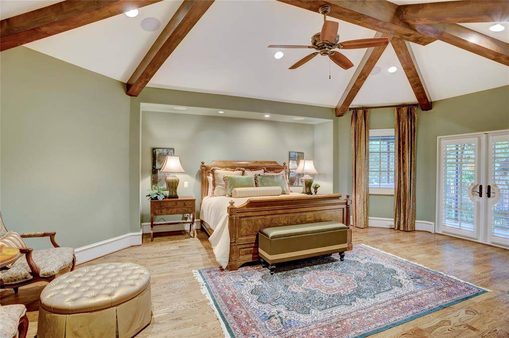 Pyramidal vaulted ceiling in master bedroom with sitting area and cantileveredbalcony overlooking backyard