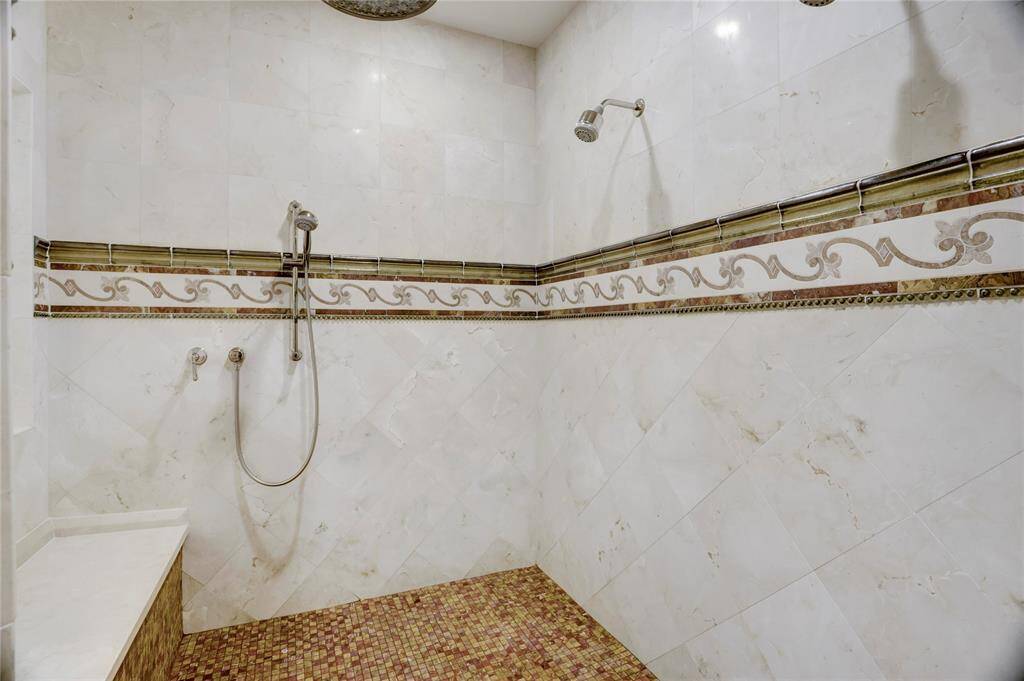 Large, beautifully tiled master shower with multiple shower heads
