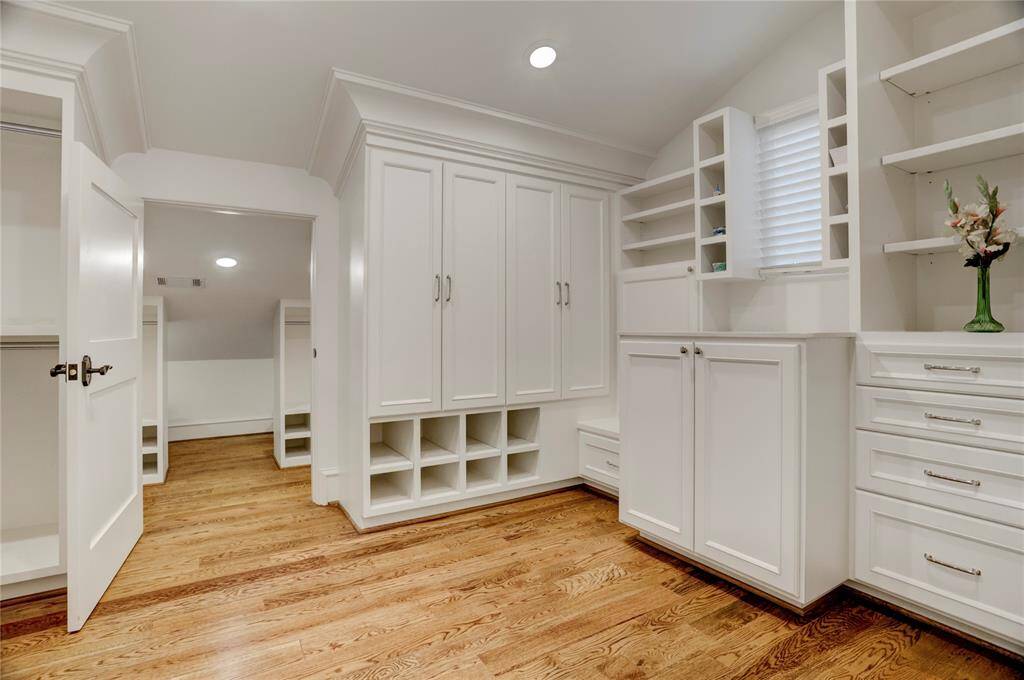 Spacious custom-built his-and-hers master closets off master bedroom with hugeamount of built-in storage