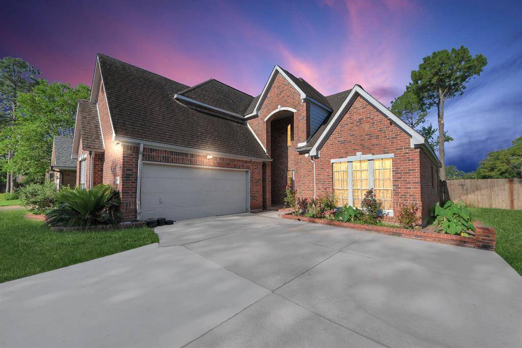 This charming brick home features a spacious driveway, a two-car garage, and well-maintained landscaping. The dramatic sky enhances its curb appeal, while large windows promise plenty of natural light inside.
