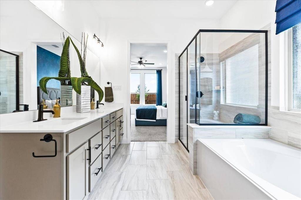 Representative photo of the Hawthorn II plan Primary Bathroom. Shown to highlight the elegant finishes, from the dazzling floors to the chic light fixtures, reflect a careful attention to detail that feels both luxurious and comforting.