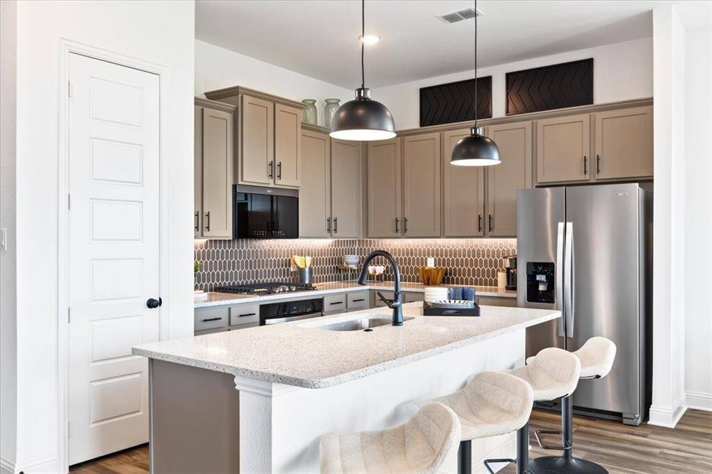 Representative photo of the Hawthorn II plan Kitchen. Shown to highlight Every detail has been thoughtfully designed, from the state-of-the-art appliances that make meal prep a breeze, to the charming backsplash that adds a touch of personality.