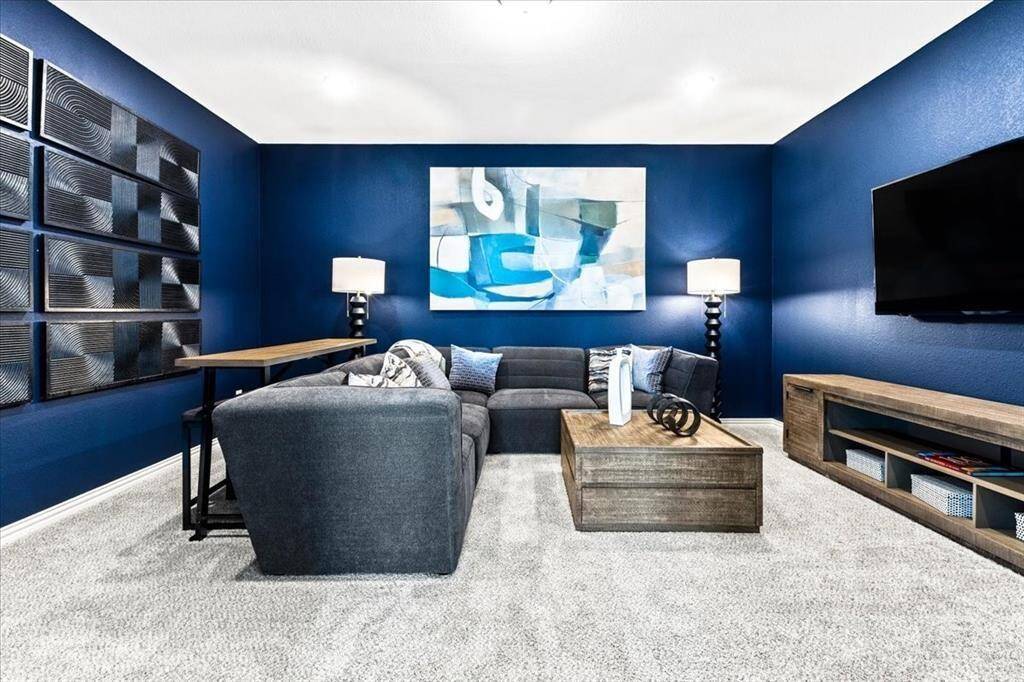 Representative photo of the Hawthorn II plan Media Room. Shown to highlight the warm, ambient lighting sets the perfect mood, whether you're gearing up for a thrilling action flick or a cozy family movie night.