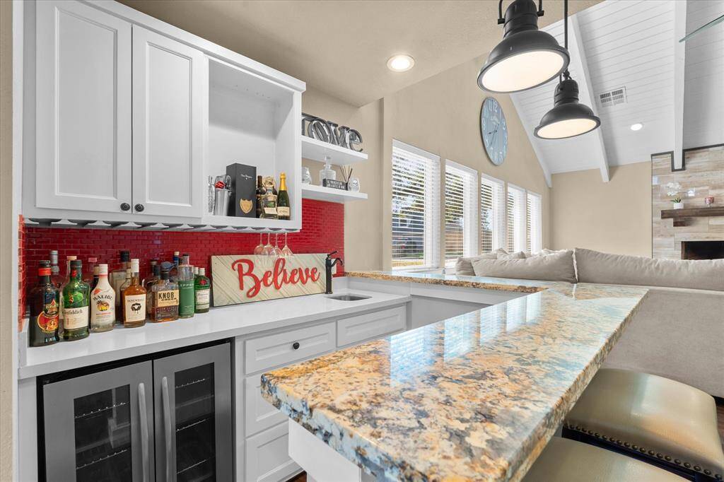 Wet bar with a sink and wine fridge.