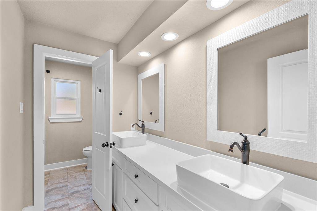 Secondary bathroom upstairs with dual sinks.
