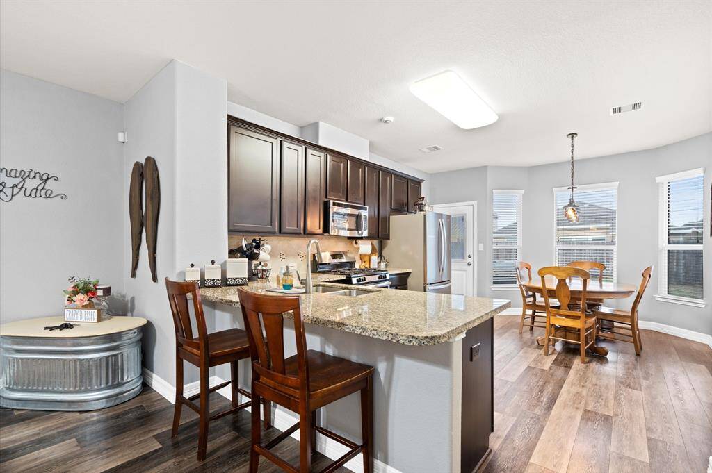 Kitchen features large breakfast bar, bay windows, granite counters and lots of room to move around..