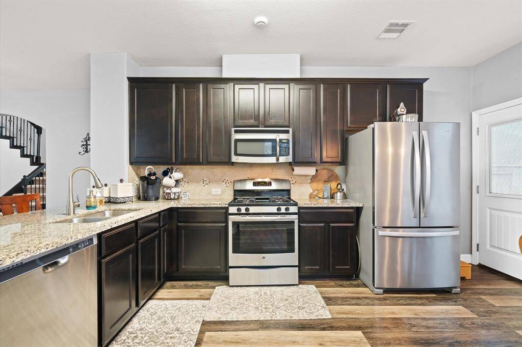 Lovely ceramic tile backsplash and stainless steel appliances.