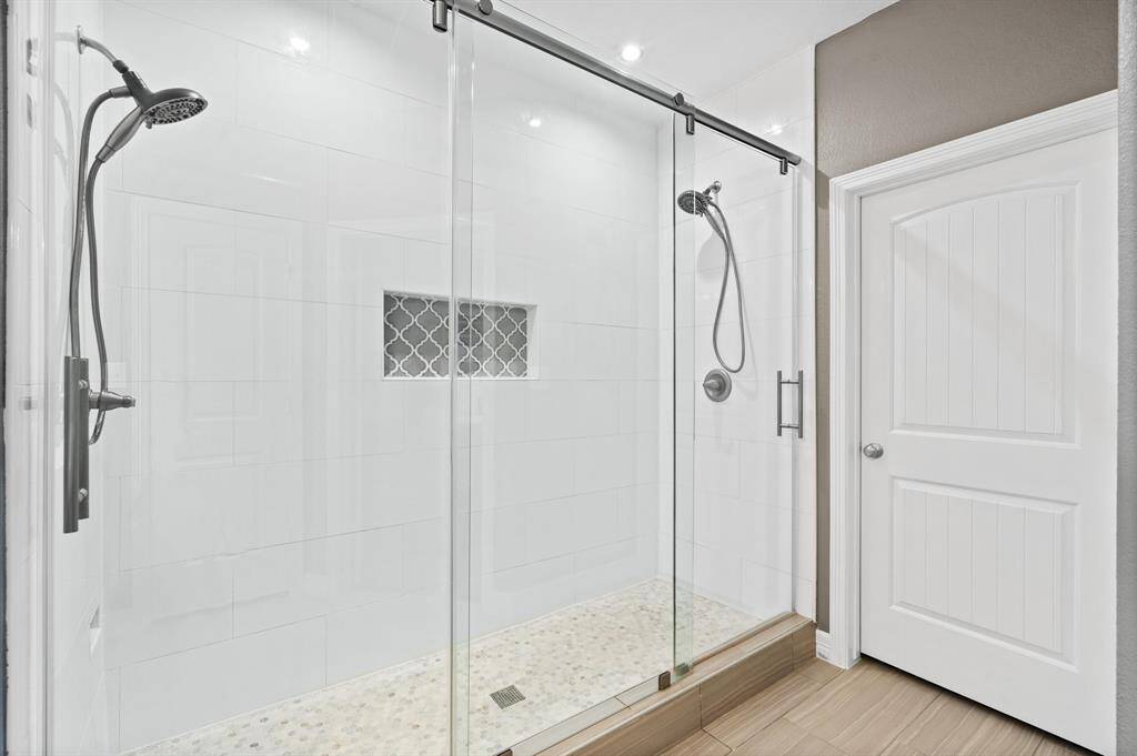 Look at the beautiful custom walk in shower with 2 shower heads and 8 feet of glass.