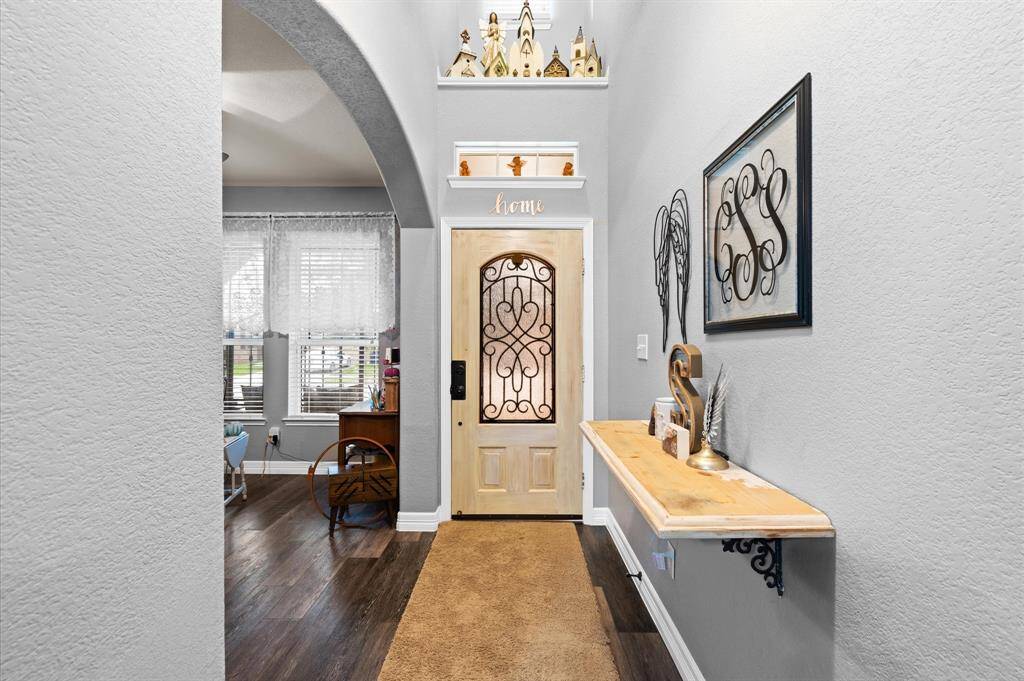 Entry features a beautiful door with iron designs and decorative shelving.