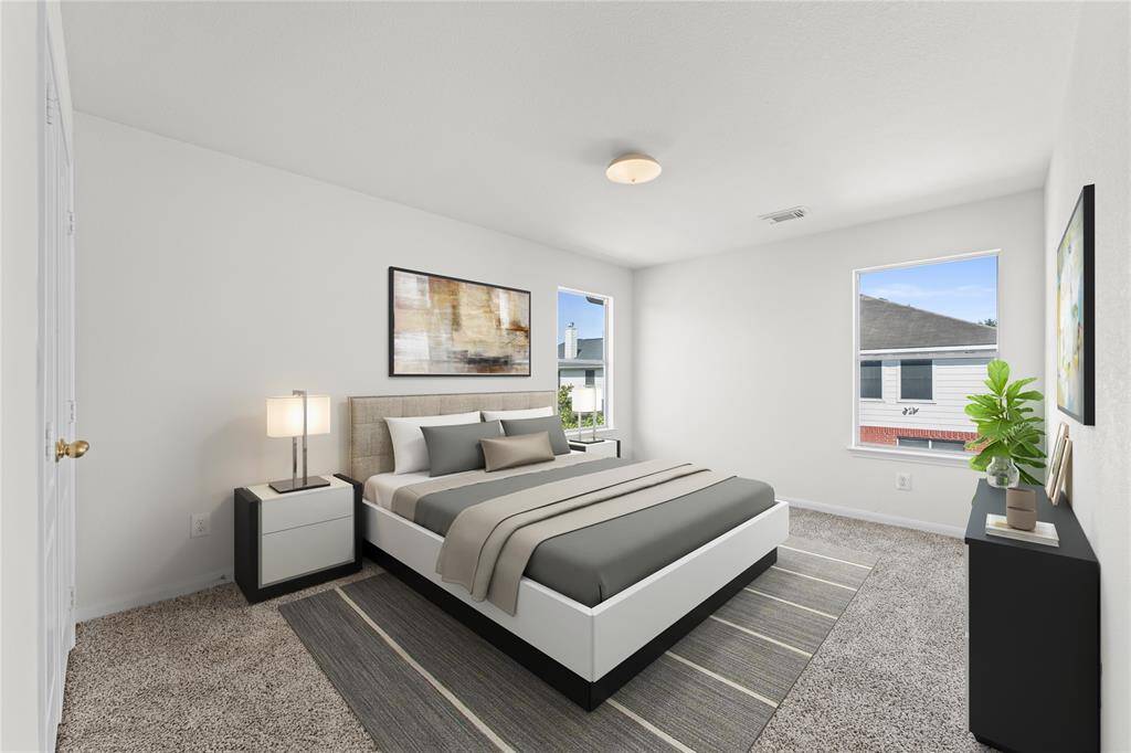 A bright and airy  third bedroom, perfect for creating a tranquil haven. Large windows fill the room with sunlight, making it feel open and inviting.