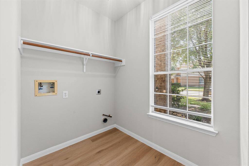 The laundry area is more than just a utility space—it’s a bright and inviting room where chores feel less like a task. A wide window allows natural light to flood the room, creating a cheerful atmosphere as you sort, fold, or wash.
