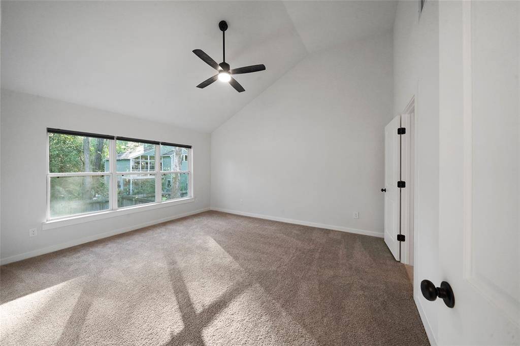 Escape to the spacious primary bedroom with vaulted ceilings and views to the backyard.
